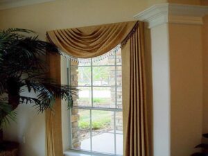 Gold drapery with beaded trim on a classic window.